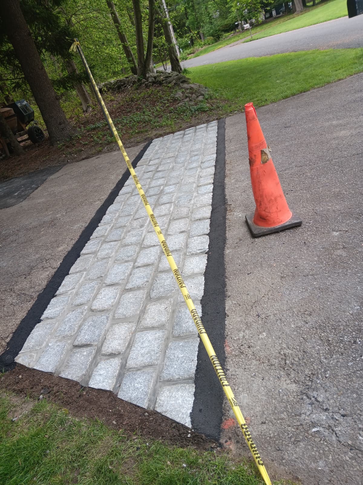 Finished granite apron detail with fresh asphalt edges
