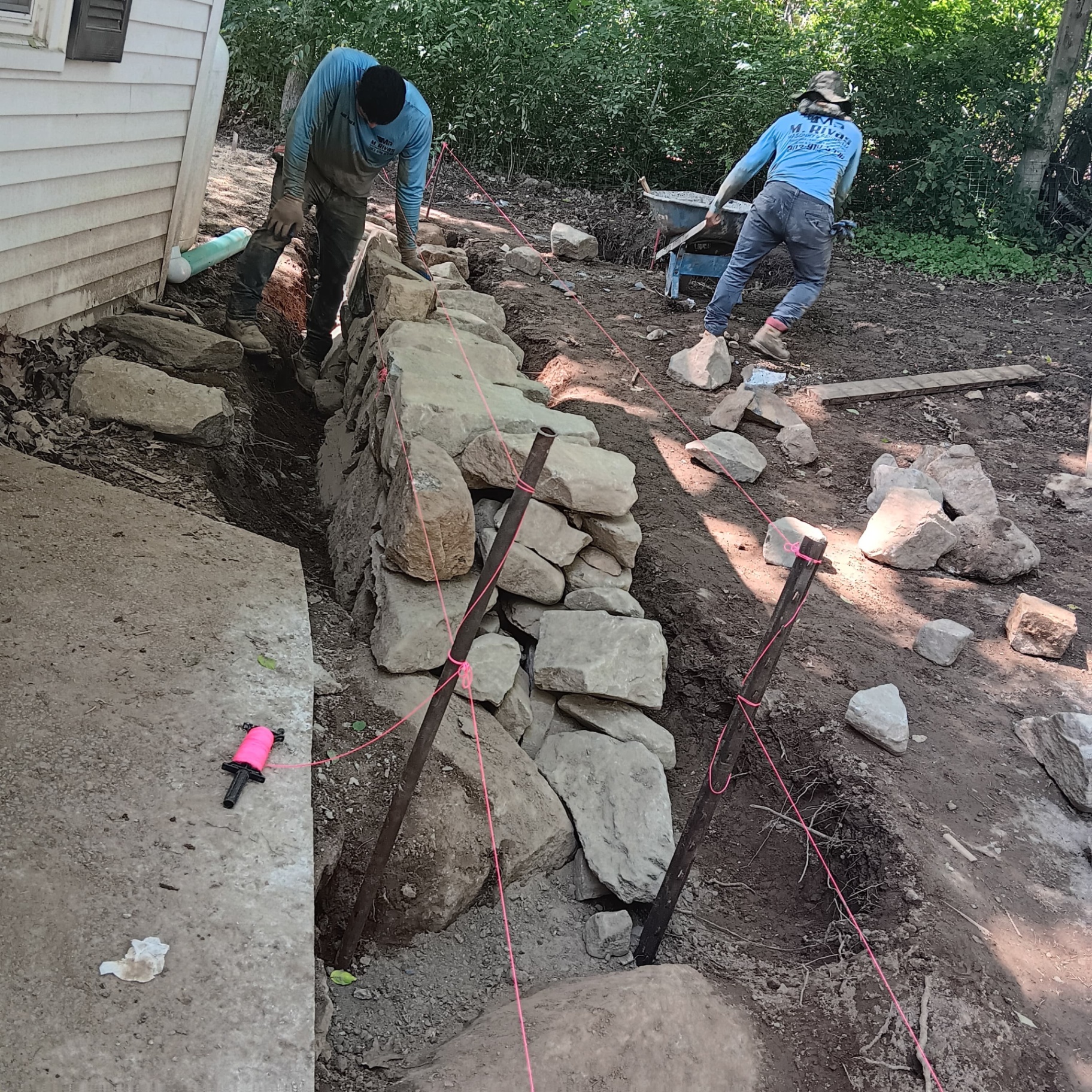 Crew building fieldstone retaining wall