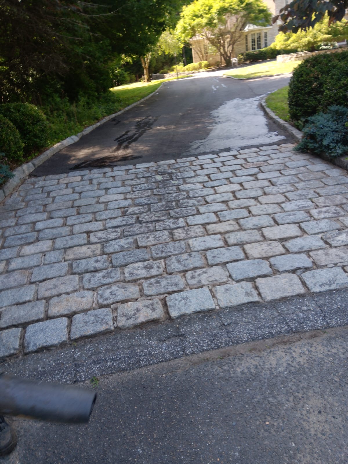 Cobblestone driveway apron leading to asphalt